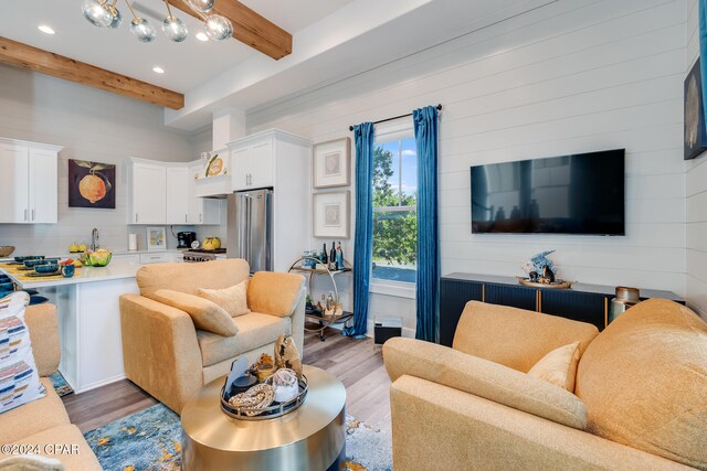 living room featuring beam ceiling and light wood-type flooring