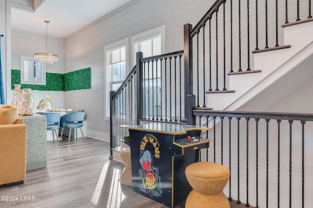 stairs featuring hardwood / wood-style floors and a chandelier