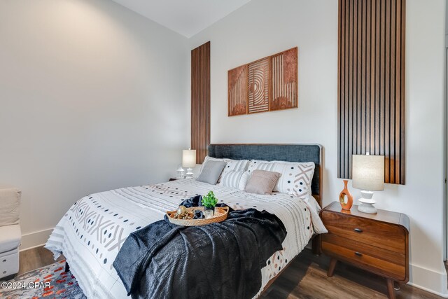 bedroom with dark hardwood / wood-style flooring