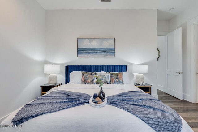 bedroom with dark hardwood / wood-style flooring