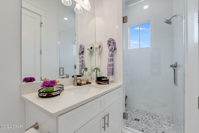 bathroom featuring vanity and a shower with door