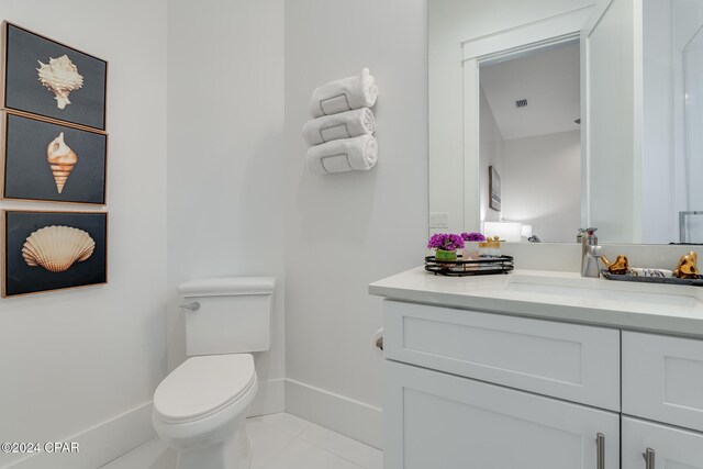 bathroom with tile patterned flooring, vanity, and toilet