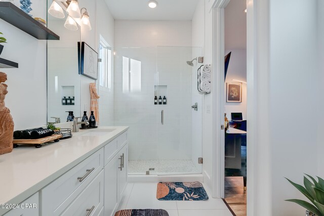 bathroom with tile patterned flooring, vanity, and walk in shower