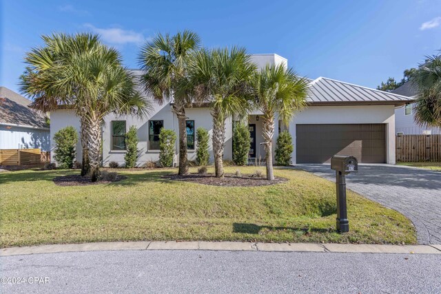 view of front of home with a garage and a front lawn