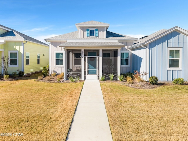 bungalow-style home with a sunroom and a front yard