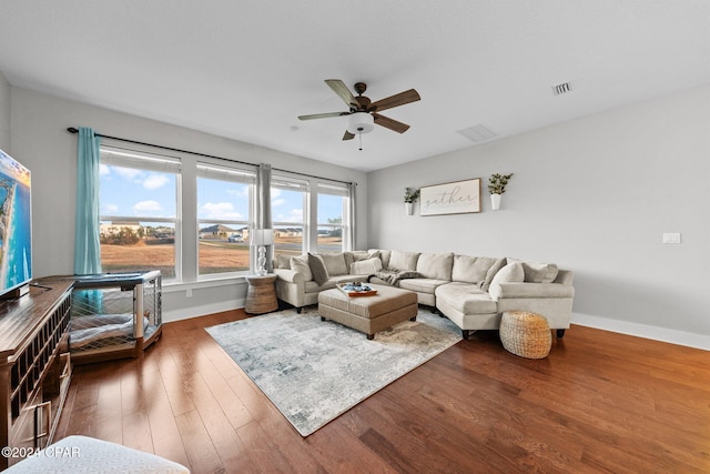 living room featuring dark hardwood / wood-style flooring and ceiling fan