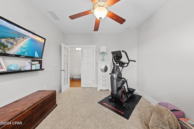 workout area featuring ceiling fan, light colored carpet, and french doors