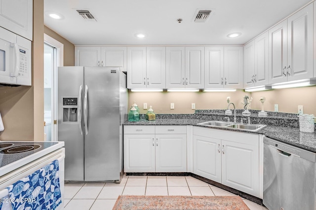 kitchen featuring sink, white cabinets, light tile patterned floors, and appliances with stainless steel finishes