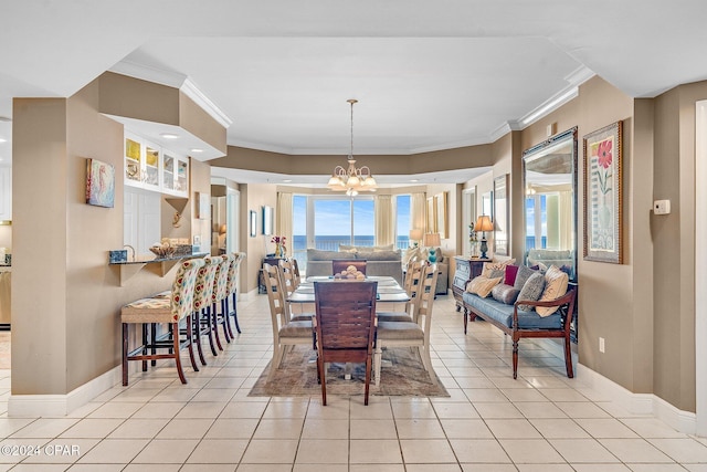 tiled dining area featuring a chandelier and crown molding