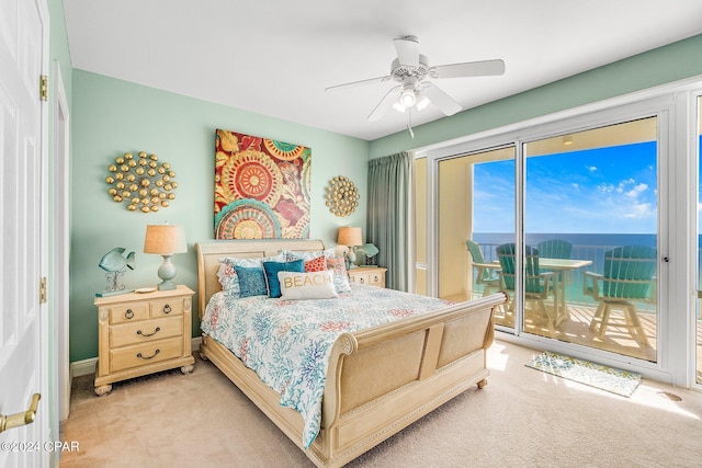 carpeted bedroom with access to exterior, a water view, and ceiling fan