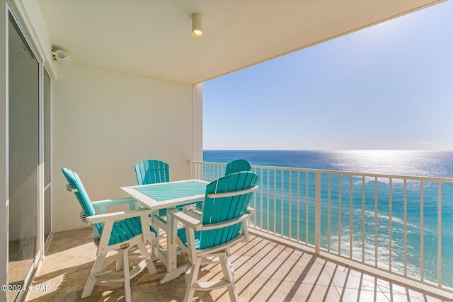 balcony featuring a beach view and a water view