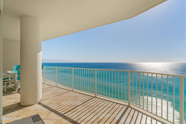 balcony featuring a beach view and a water view