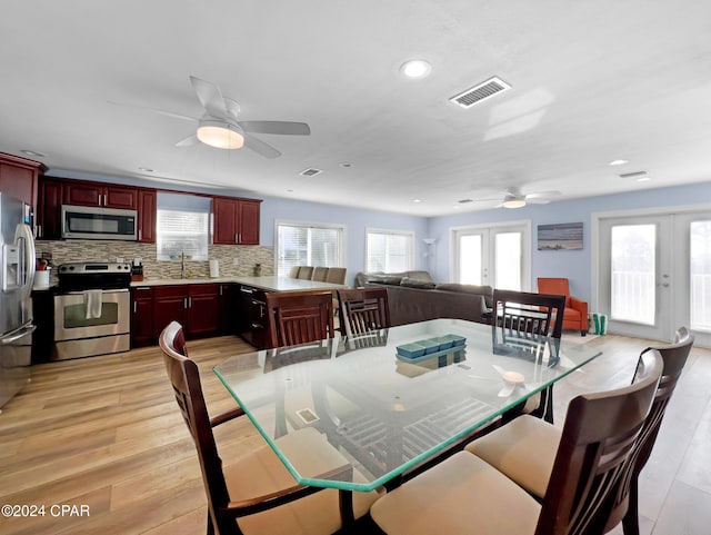 dining room featuring visible vents, light wood-style floors, ceiling fan, and french doors