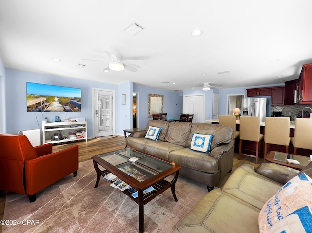 living area with recessed lighting, visible vents, wood finished floors, and a ceiling fan