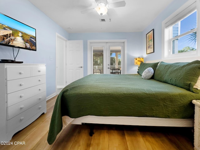 bedroom featuring visible vents, multiple windows, wood finished floors, and access to outside