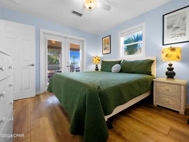 bedroom with visible vents, access to outside, french doors, wood-type flooring, and ceiling fan