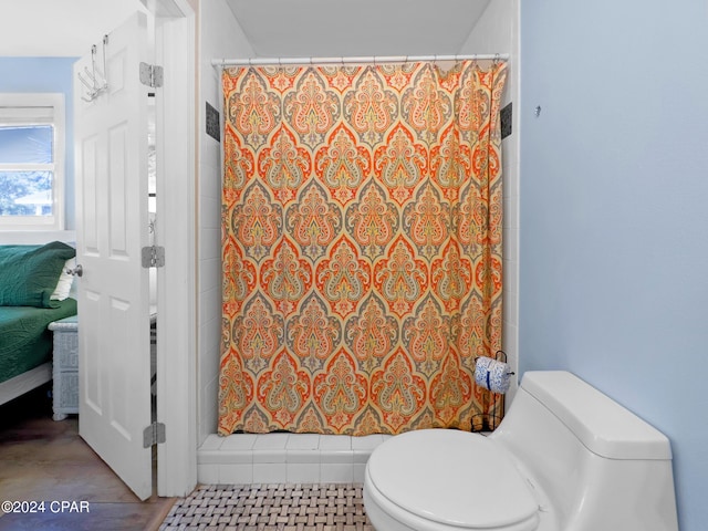 bathroom with curtained shower and toilet