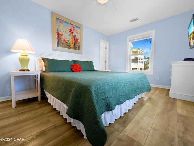 bedroom featuring wood finished floors, visible vents, and baseboards