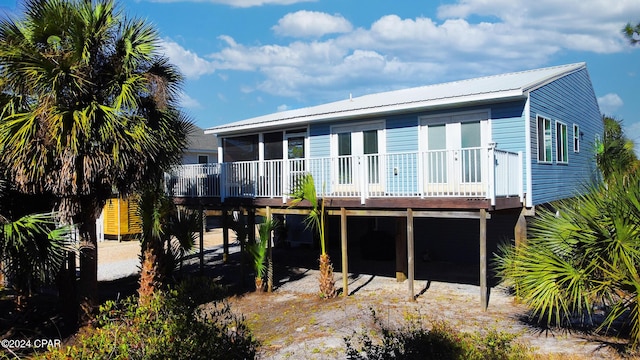 rear view of property featuring metal roof and a carport