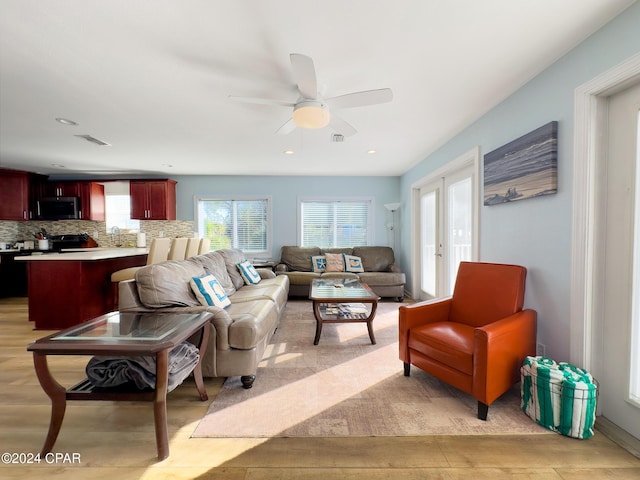 living area with recessed lighting, a ceiling fan, visible vents, and french doors