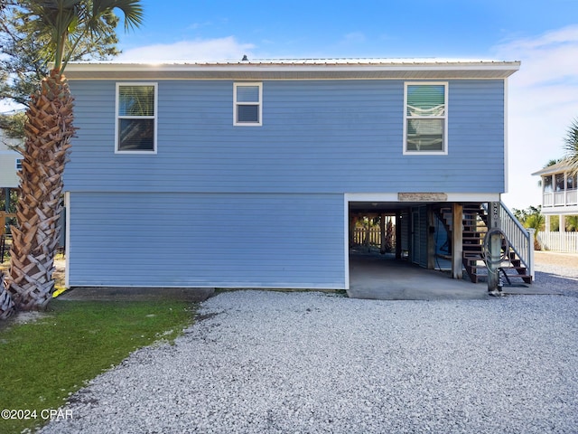 rear view of house featuring stairway and a carport