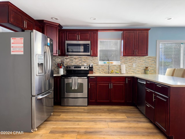 kitchen featuring dark brown cabinets, appliances with stainless steel finishes, light countertops, and a peninsula