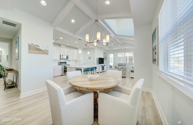 dining space featuring vaulted ceiling with beams, sink, light hardwood / wood-style floors, and a notable chandelier