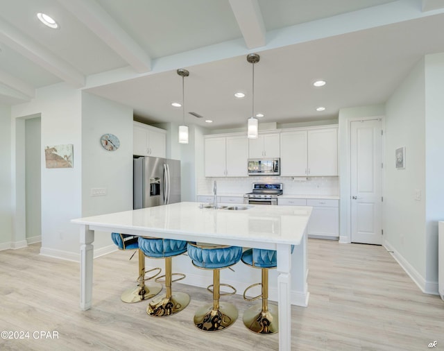 kitchen featuring appliances with stainless steel finishes, a kitchen island with sink, sink, beamed ceiling, and white cabinetry