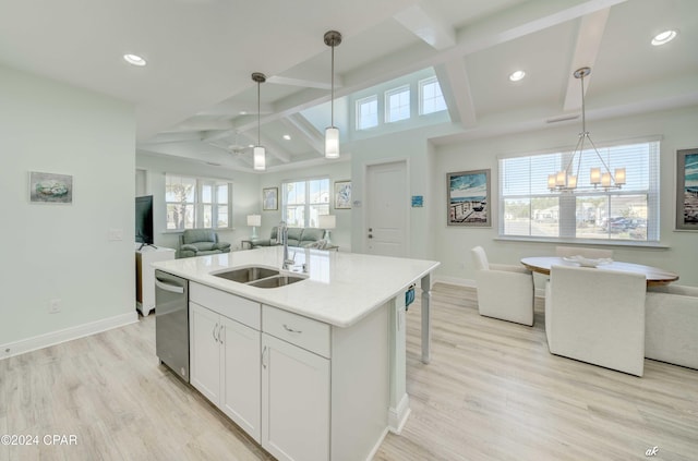 kitchen with white cabinetry, sink, hanging light fixtures, light hardwood / wood-style flooring, and an island with sink