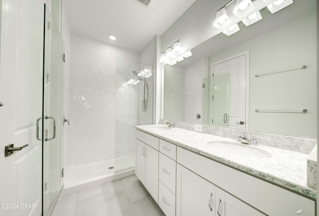 bathroom featuring vanity, tile patterned floors, and a shower with shower door