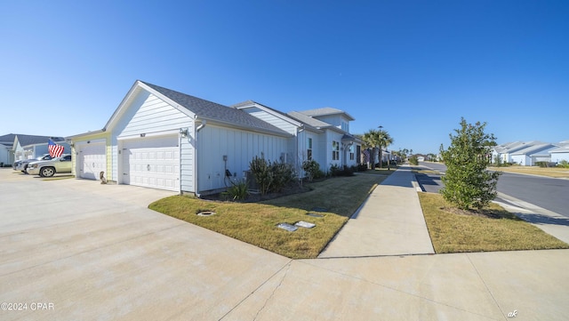 view of side of home featuring a lawn and a garage