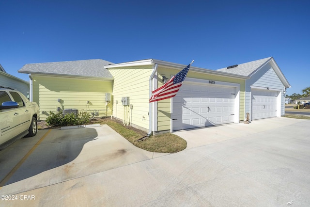 view of side of property with a garage and central AC unit