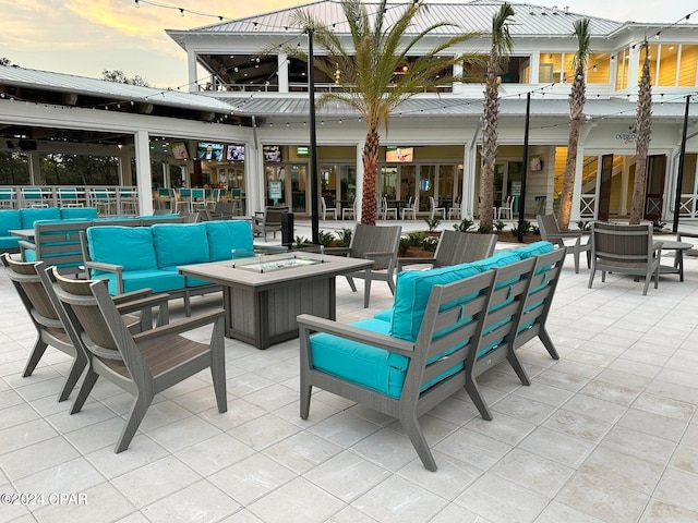 patio terrace at dusk featuring an outdoor living space with a fire pit