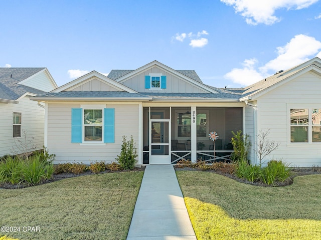 view of front of property featuring a sunroom and a front yard