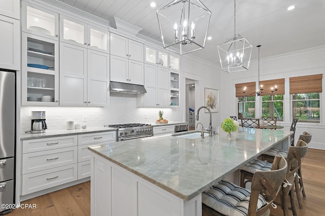 kitchen with pendant lighting, white cabinets, sink, appliances with stainless steel finishes, and a large island