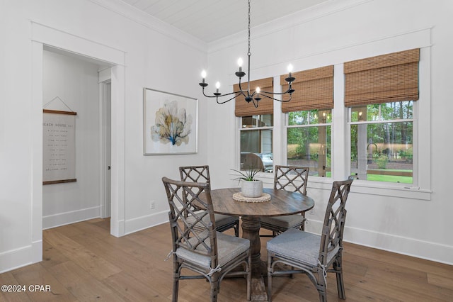 dining space featuring hardwood / wood-style flooring, crown molding, and an inviting chandelier