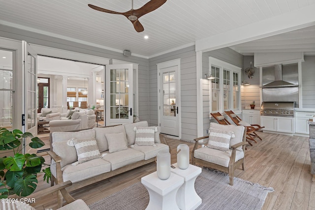 living room featuring light wood-type flooring, ceiling fan, wooden walls, and wood ceiling