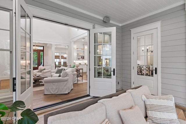 sunroom featuring decorative columns, french doors, and a chandelier