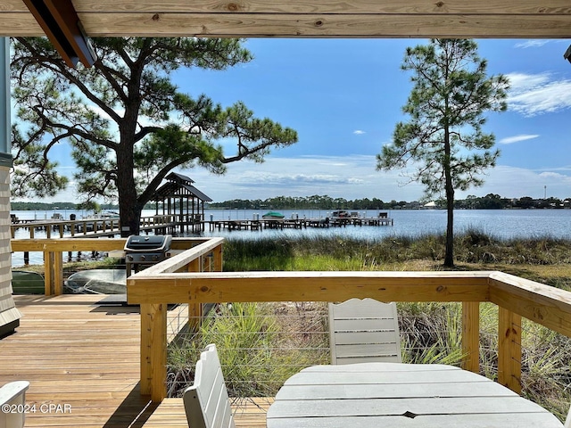 deck with a water view and area for grilling