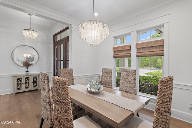 dining area with a chandelier, hardwood / wood-style flooring, and crown molding