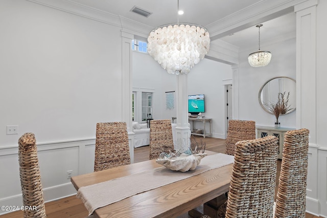 dining room featuring hardwood / wood-style floors, crown molding, and a notable chandelier