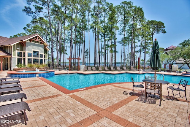 view of swimming pool with a patio area and a community hot tub