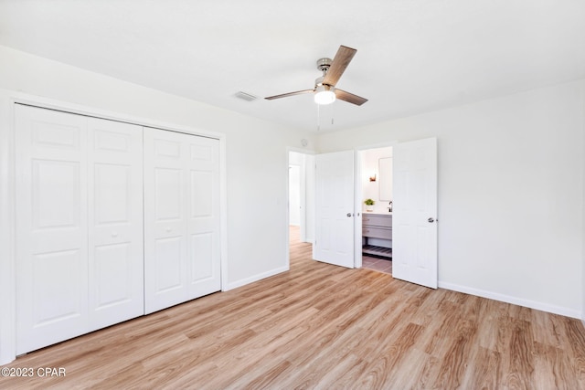 unfurnished bedroom with light wood-type flooring, a closet, ceiling fan, and connected bathroom