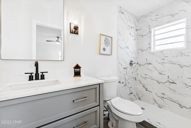 bathroom featuring a tile shower, vanity, and toilet