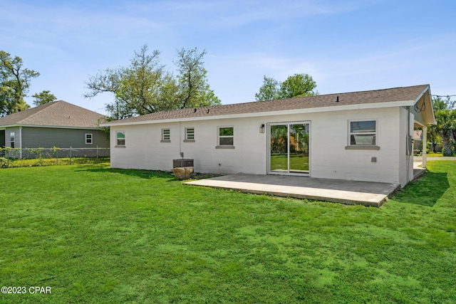 rear view of house with a patio, central AC, and a lawn