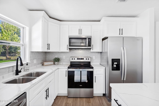 kitchen with white cabinets, appliances with stainless steel finishes, and sink