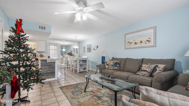 living room featuring a ceiling fan, visible vents, and light tile patterned floors