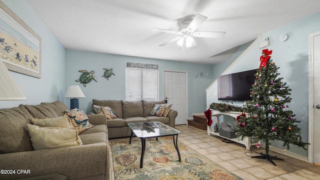 living area featuring a ceiling fan, baseboards, and tile patterned floors