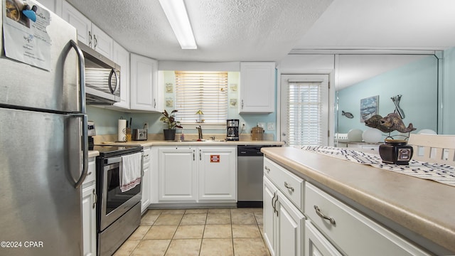 kitchen featuring appliances with stainless steel finishes, light countertops, white cabinets, and a sink