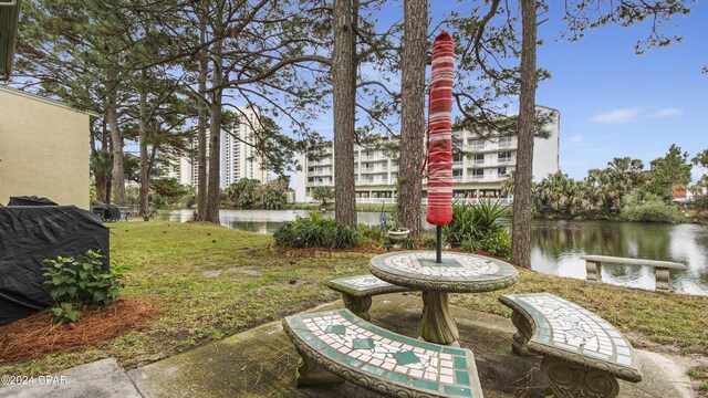 view of community featuring a lawn and a water view